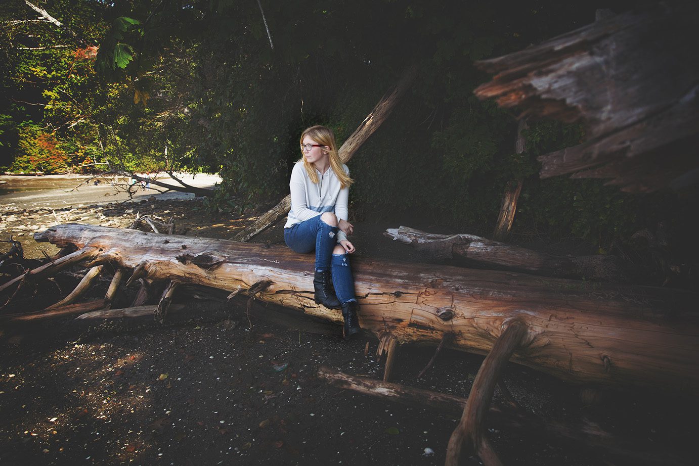 teenage girl on log by water in Olympia Washington by Juniper Lynne Photography