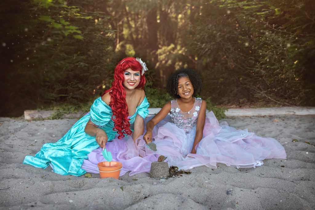 black girl with princess Ariel on beach making a sandcastle for character experience in Western Washington 