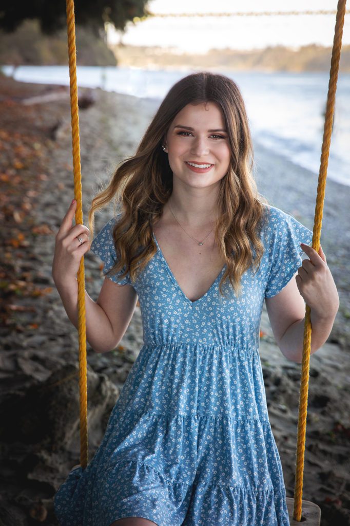 class of 2021 high school senior girl on tree swing on beach with beach and Tacoma Narrows behind her, photo by Juniper Lynne Photography. 