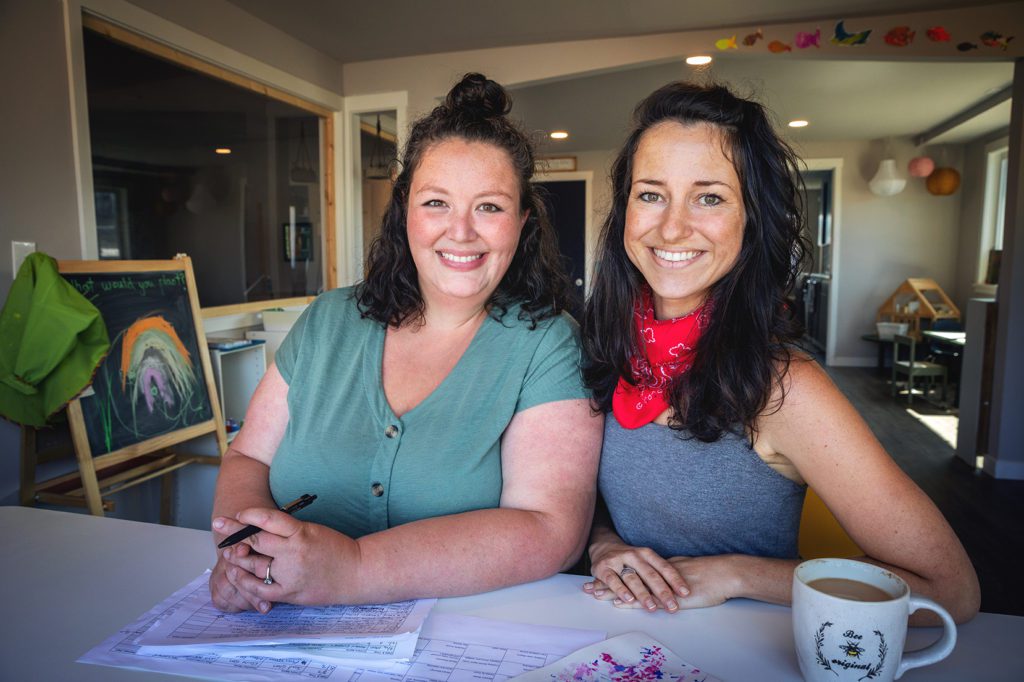 two women business owners of the co-lab in tacoma at desk with papers and coffee