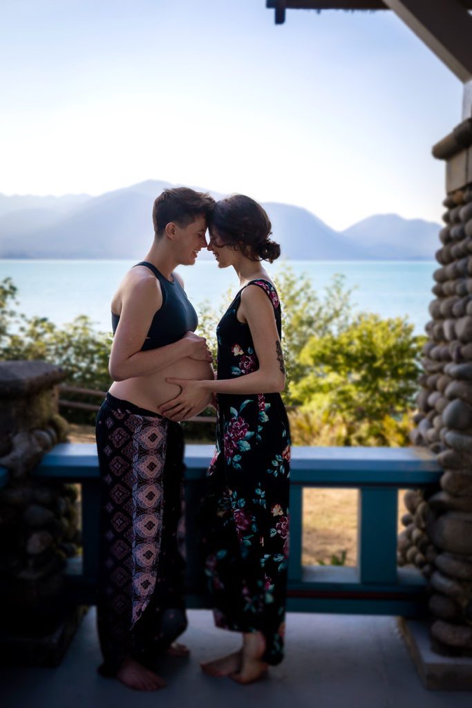 Lesbian maternity portrait with Hood Canal and Olympic Mountains in background. 